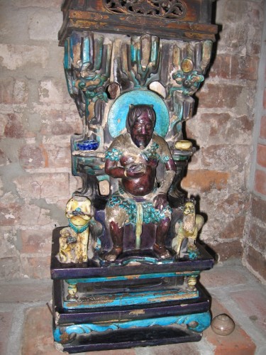Here he sits in the bricked up fireplace of our bedroom in Brooklyn. I give him a bit of gin now and then. I’ve no idea what is in the hand he holds to his chest…